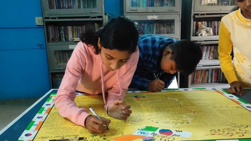 Students writing together on the wall magazine