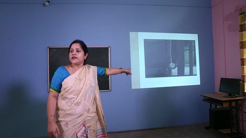 A teacher pointing to a projected slide