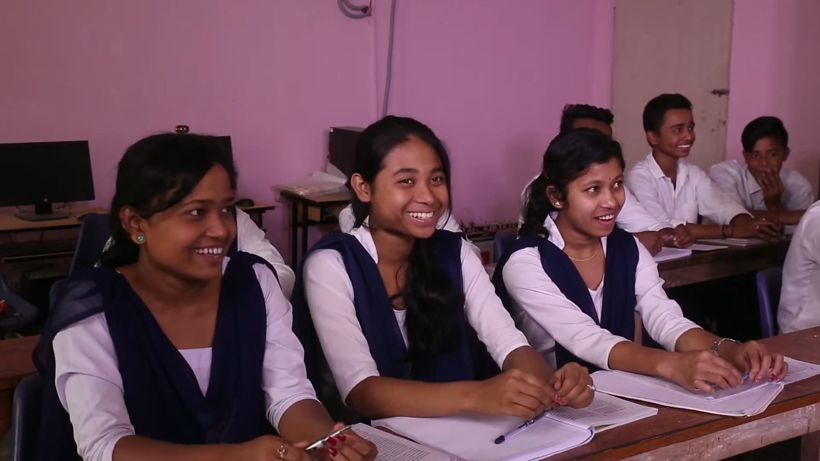 Students smiling at their desks during a lesson