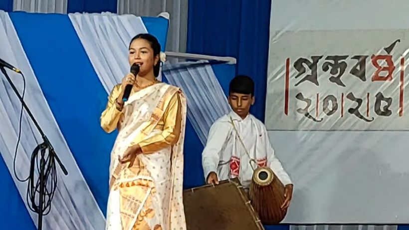 A student singing with a boy on dhol