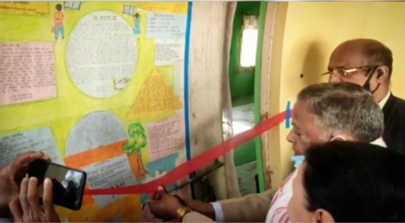 A guest looking closely at a student chart on the wall