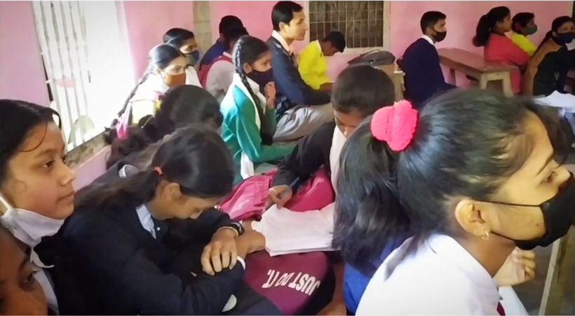 Students in masks writing at their desks